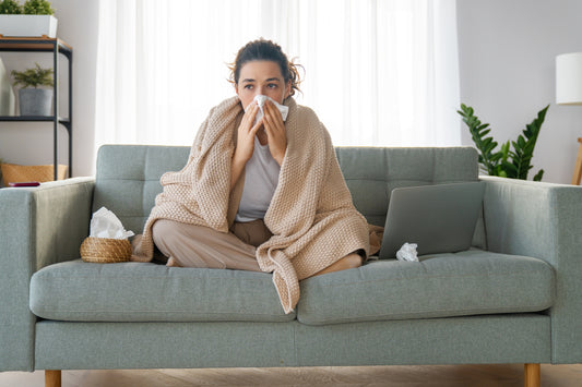 Woman Blowing Nose While Sitting on Couch